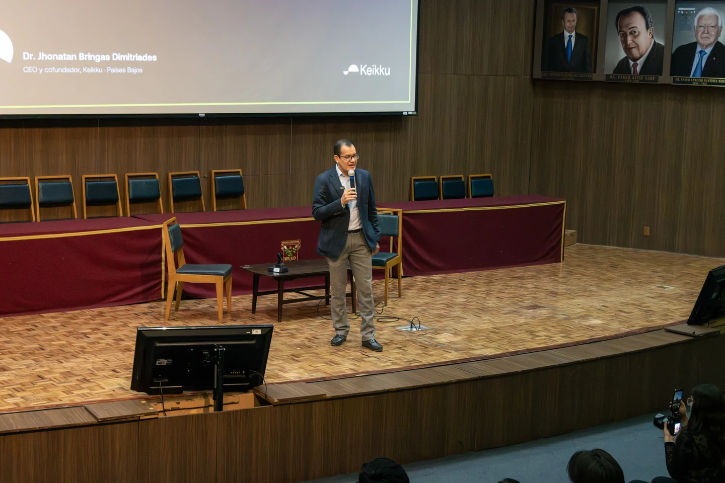 Dr. Julio Sauza durante una presentación en un auditorio.