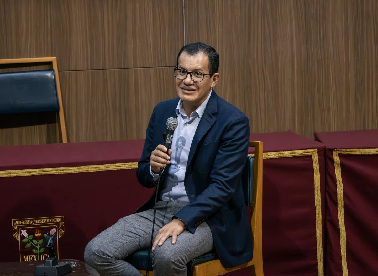 Dr. Julio Sauza participando con micrófono en un auditorio.